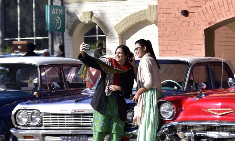 Visitors take selfies at a vintage and classic car show in Peshawar, Pakistan on Nov. 30, 2024. Photo: Xinhua