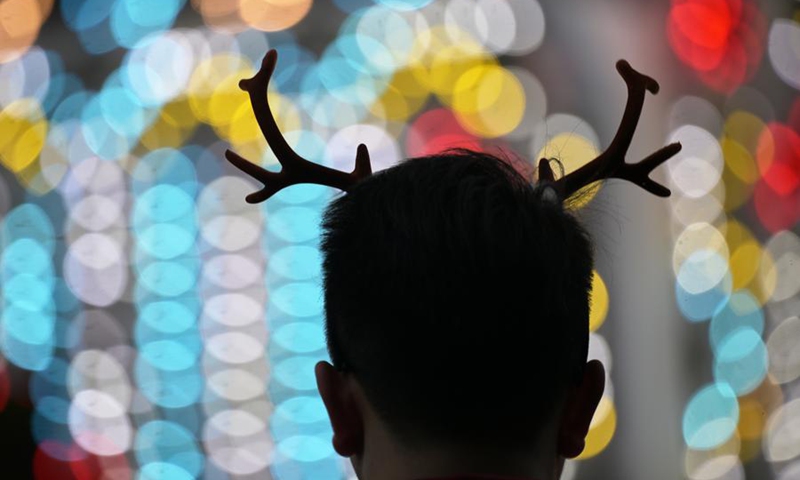 A man enjoys Christmas Wonderland light decorations at Singapore's Gardens by the Bay on Dec. 1, 2024. Photo: Xinhua