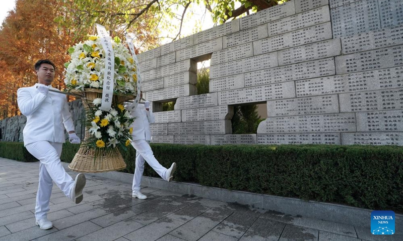 Staff members present a flower basket during the family commemoration for victims of the Nanjing Massacre in Nanjing, east China's Jiangsu Province, Dec. 1, 2024. Photo: Xinhua