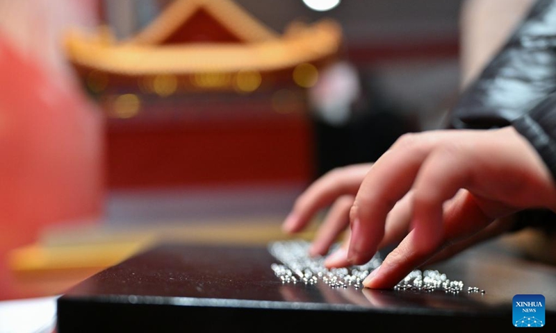 A student from the Beijing School for the Blind reads the braille version of introductions at Sensory Experience Gallery of the Palace Museum in Beijing, capital of China, Dec. 1, 2024. Sensory Experience Gallery, co-founded by Palace Museum and China Disabled Persons' Federation, was inaugurated here on Sunday, featuring creative cultural works, cultural experiences, and study tours. It integrates multi-sensory experiences to make culture more accessible for people with disabilities. Photo: Xinhua