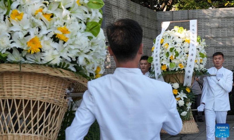 Staff members present flower baskets during the family commemoration for victims of the Nanjing Massacre in Nanjing, east China's Jiangsu Province, Dec. 1, 2024. Photo: Xinhua