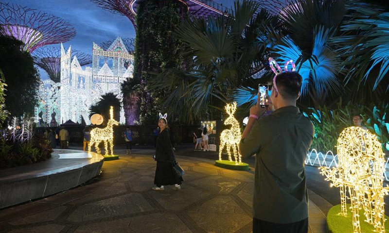 People take photos of Christmas Wonderland light decorations at Singapore's Gardens by the Bay on Dec. 1, 2024. Photo: Xinhua