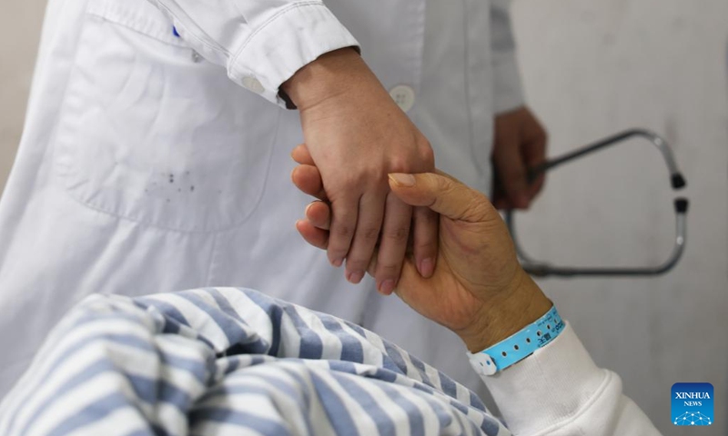 Zhao Rui shakes hands with a patient at a ward of the Department of Infectious Diseases at the Fourth People's Hospital of Nanning, in Nanning, south China's Guangxi Zhuang Autonomous Region, Nov. 21, 2024. (Photo: Xinhua)