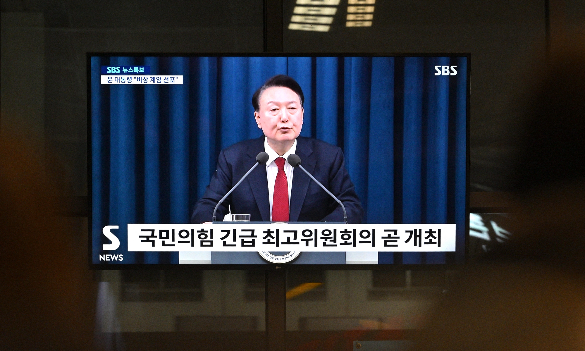 A television screen shows South Korea's President Yoon Suk-yeol speaking during a news broadcast at a train station in Seoul on December 3, 2024, after he declared emergency martial law. Photo: AFP