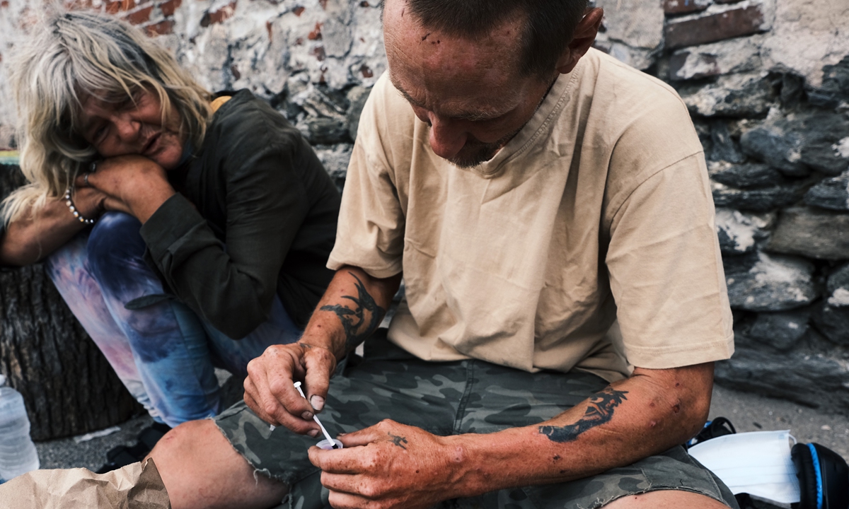 Homeless individuals inject a mixture of heroin and fentanyl on a street in Pennsylvania, the US. Photo: VCG