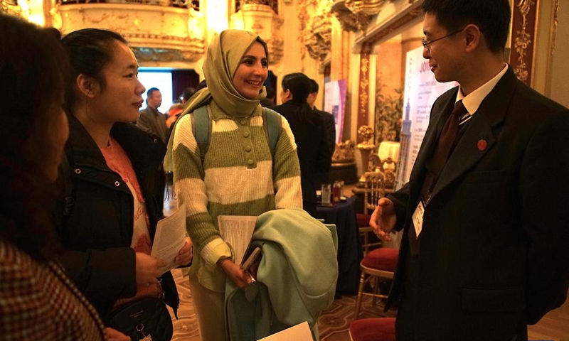 A staff member talks with visitors at the Study in China education exhibition in Prague, the Czech Republic, on Dec. 2, 2024.  (Photo: Xinhua)