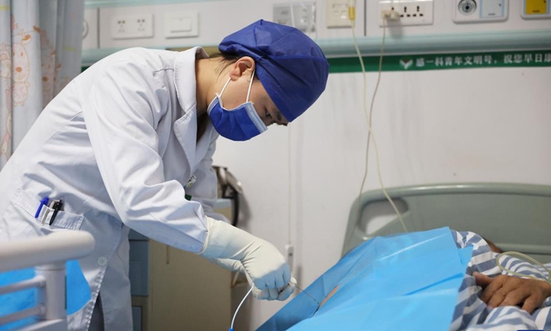 Zhao Rui performs treatment on a patient at a ward of the Department of Infectious Diseases at the Fourth People's Hospital of Nanning, in Nanning, south China's Guangxi Zhuang Autonomous Region, Nov. 24, 2024. (Photo: Xinhua)