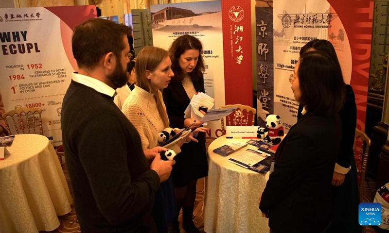 A staff member talks with visitors at the Study in China education exhibition in Prague, the Czech Republic, on Dec. 2, 2024. Thirteen Chinese universities showcased their diverse programs and policies at the Study in China education exhibition held in Prague on Monday, underscoring the deepening educational and cultural ties between China and the Czech Republic. (Photo: Xinhua)