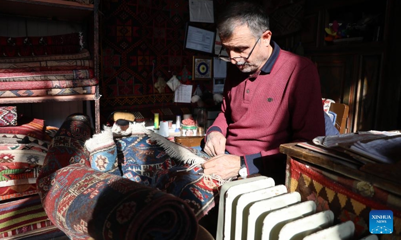 A senior works at a carpet store in Ankara, Türkiye, on Dec. 2, 2024. Türkiye's high cost of living is pushing an increasing number of seniors back into the workforce to make ends meet, according to a leading pensioners' association. (Photo: Xinhua)