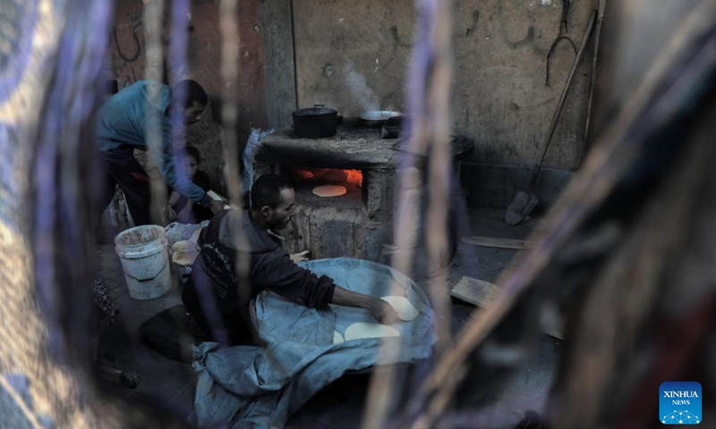 Palestinians bake bread with an old clay oven in the southern Gaza Strip city of Khan Younis, on Dec. 2, 2024. (Photo: Xinhua)