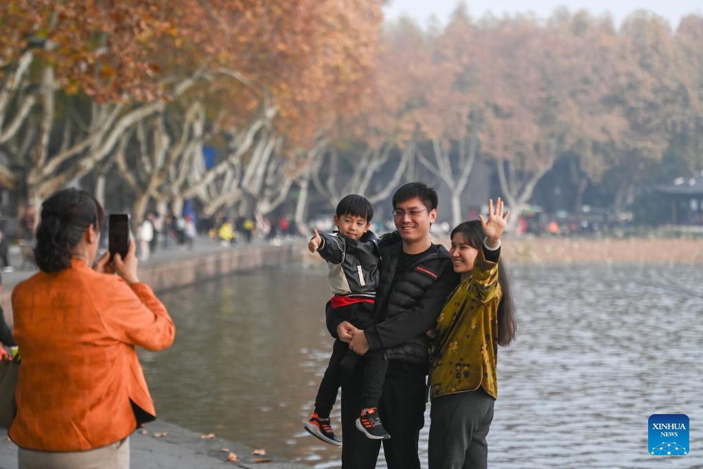 Tourists pose for photos in the West Lake scenic area in Hangzhou, east China's Zhejiang Province, Dec. 3, 2024. (Photo: Xinhua)