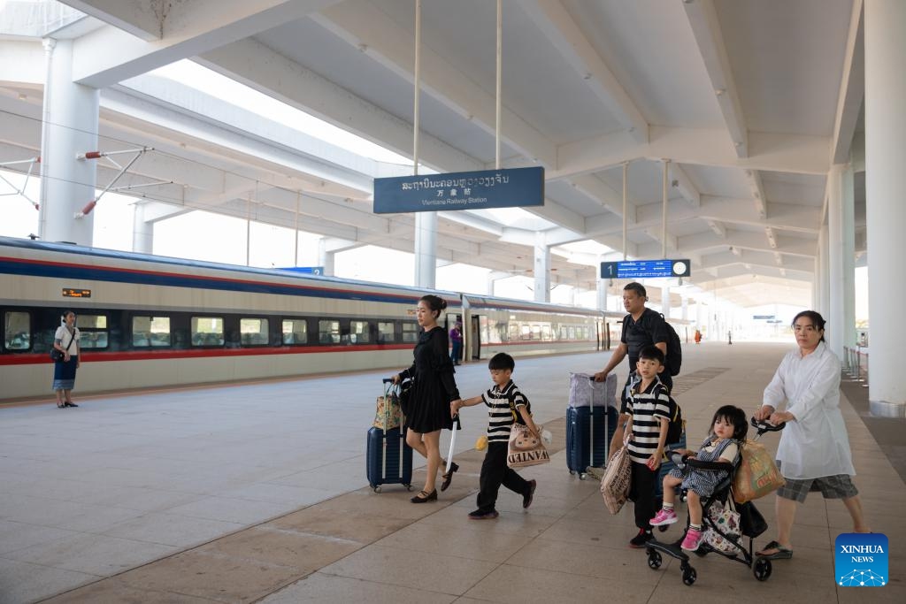 Passengers walk to board a train of the China-Laos Railway at the Vientiane Station in Vientiane, Laos, Dec. 2, 2024. The China-Laos Railway has emerged as a catalyst for regional economic growth three years after its launch, China's railway operator said on Tuesday. Offering a safe and sustainable operation, the railway had handled over 43 million passenger trips and transported 48.3 million tonnes of cargo as of Monday, according to the China State Railway Group Co., Ltd. (Photo: Xinhua)