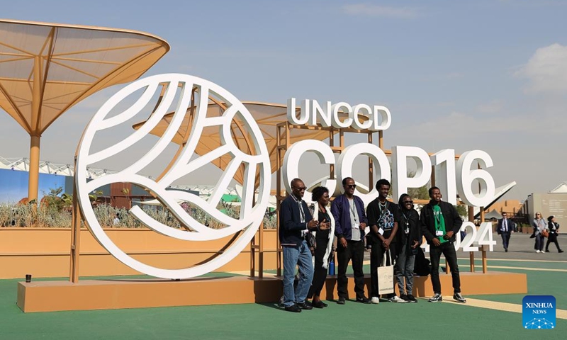 People pose for photos in front of an installation of the 16th Conference of the Parties (COP16) to the United Nations Convention to Combat Desertification (UNCCD) in Riyadh, Saudi Arabia, on Dec. 3, 2024. COP16, held from Dec. 2 to 13 under the theme Our Land. Our Future, is the largest UN land-focused conference to date and the first UNCCD COP in the Middle East and North Africa. (Photo: Xinhua)