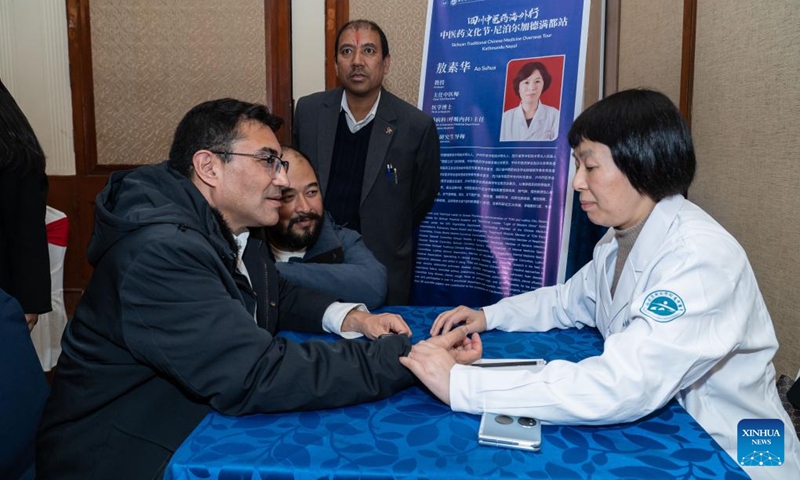 A doctor from the Affiliated Traditional Chinese Medicine Hospital of Southwest Medical University makes a free diagnosis during a traditional Chinese medicine (TCM) overseas tour in Kathmandu, Nepal, on Dec. 3, 2024. (Photo: Xinhua)