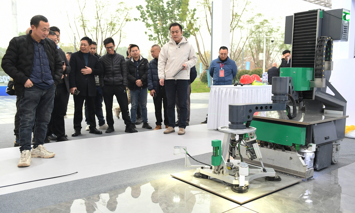 A crowd gathers at a robotics competition in Southwest China's Chongqing to watch a robot demonstrate its tile-laying skills.  
By the end of 2023, China had a total of 4.282 million operational industrial robots, accounting for 41 percent of the global stock. The robot density in China's manufacturing sector has reached 470 units per 10,000 workers, ranking third globally. Photo: VCG