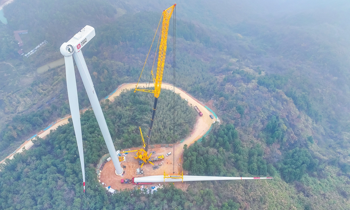 Workers hoist wind turbine blades at the construction site for the second phase of the Henglishan Wind Farm in Ruichang, East China's Jiangxi Province, on December 4, 2024. The city has been vigorously developing green and clean energy. In the first half of this year, China's installed capacity of renewable energy surpassed that of coal power for the first time in its history. Photo: VCG