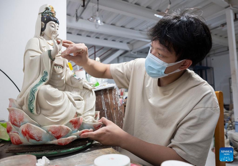 An apprentice polishes a ceramic piece at an art studio of Meitaowan in Foshan, south China's Guangdong Province, Dec. 3, 2024. Meitaowan, literally translated as bay of beautiful ceramics, has been known for its development in ceramic arts. The municipal government established this area by transforming old factory buildings into cultural facilities and creative spaces. It is now home to studios of numerous ceramic art masters and fashion brands that aim to drive urban renewal and industrial transformation. Photo: Xinhua