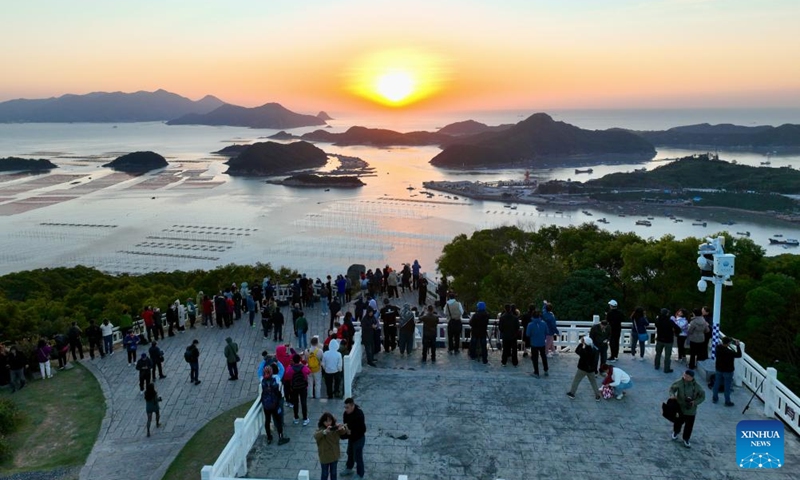 An aerial drone photo shows tourists enjoying the sunrise scenery in Huazhu Village of Sansha Town in Xiapu County, southeast China's Fujian Province, Nov. 29, 2024. Xiapu County is blessed with sinuate seashore along with numerous tidal flats, islands and reefs. Through coordinated strategies for both ecological conservation and economic development, the county has transformed itself into a stunning hub of thriving tourism industry. Photo: Xinhua