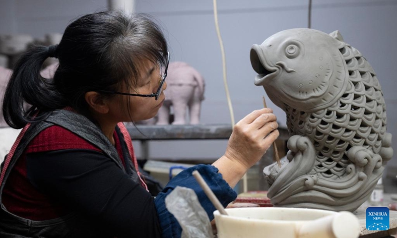 A worker hones a ceramic piece at an art studio of Meitaowan in Foshan, south China's Guangdong Province, Dec. 3, 2024. Meitaowan, literally translated as bay of beautiful ceramics, has been known for its development in ceramic arts. The municipal government established this area by transforming old factory buildings into cultural facilities and creative spaces. It is now home to studios of numerous ceramic art masters and fashion brands that aim to drive urban renewal and industrial transformation. Photo: Xinhua