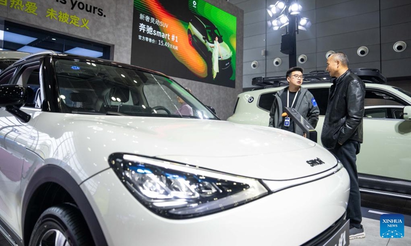 A staff member (L) introduces a car to a visitor at the 20th China (Changsha) International Automobile Exposition in Changsha, central China's Hunan Province, Dec. 4, 2024. The 6-day exposition, with an exhibition area of 120,000 square meters, kicked off on Wednesday at the Changsha International Convention and Exhibition Center, showcasing more than 1,000 vehicles from over 80 automobile brands. Photo: Xinhua