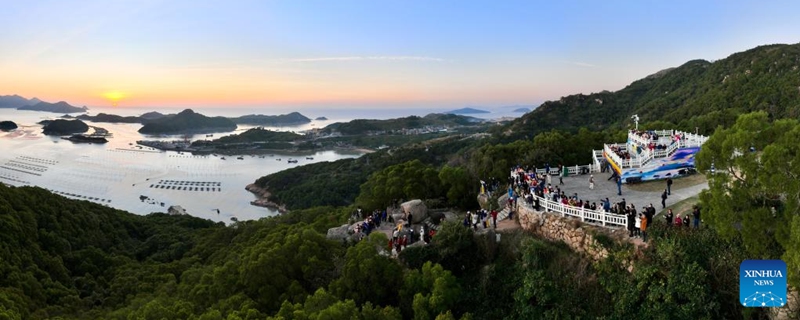 An aerial panoramic drone photo shows tourists enjoying the sunrise scenery in Huazhu Village of Sansha Town in Xiapu County, southeast China's Fujian Province, Nov. 29, 2024. Xiapu County is blessed with sinuate seashore along with numerous tidal flats, islands and reefs. Through coordinated strategies for both ecological conservation and economic development, the county has transformed itself into a stunning hub of thriving tourism industry. Photo: Xinhua