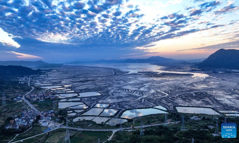 An aerial drone photo shows the evening glow over the seaside in Xiapu County, southeast China's Fujian Province, Nov. 30, 2024. Xiapu County is blessed with sinuate seashore along with numerous tidal flats, islands and reefs. Through coordinated strategies for both ecological conservation and economic development, the county has transformed itself into a stunning hub of thriving tourism industry. Photo: Xinhua