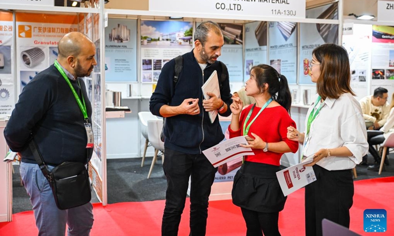 A visitor talks with exhibitors at China Plastics Industry (Türkiye) Brand Exhibition in Istanbul, Türkiye, Dec. 4, 2024. The four-day-long exhibition opened here on Wednesday and is held in parallel with the Plast Eurasia Istanbul 2024. Photo: Xinhua