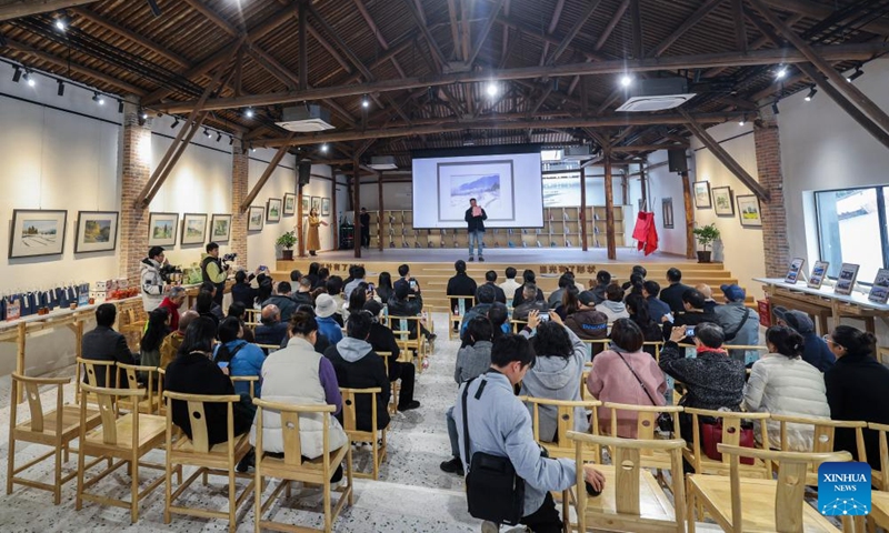 An artist introduces his rural-themed painting at the Changling Hill art space in Changling Village of Jiande City in east China's Zhejiang Province, Dec. 6, 2024. An art exhibition, presenting more than 50 rural-themed watercolor paintings, opened in Changling Village on Friday. (Photo: Xinhua)