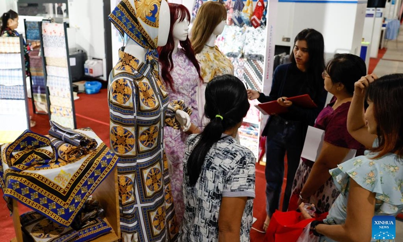 People visit an exhibition booth during the 2024 Myanmar International Textile and Machinery Fair in Yangon, Myanmar, Dec. 6, 2024. The 2024 Myanmar International Textile and Machinery Fair kicked off in Yangon on Friday. Photo: Xinhua