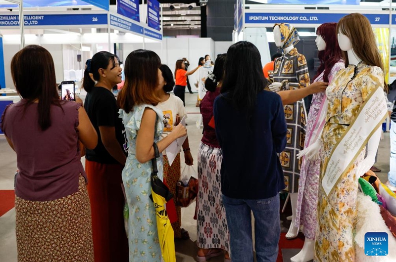 People visit an exhibition booth during the 2024 Myanmar International Textile and Machinery Fair in Yangon, Myanmar, Dec. 6, 2024. The 2024 Myanmar International Textile and Machinery Fair kicked off in Yangon on Friday. Photo: Xinhua