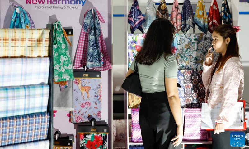 A visitor visits an exhibition booth during the 2024 Myanmar International Textile and Machinery Fair in Yangon, Myanmar, Dec. 6, 2024. The 2024 Myanmar International Textile and Machinery Fair kicked off in Yangon on Friday. The event was organized by the Chinese Textile & Garment Association in Myanmar (CTGA) in collaboration with the Myanmar Garment Manufacturers Association (MGMA). Photo: Xinhua