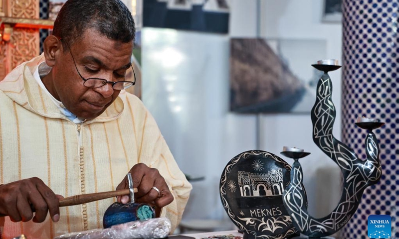 A Moroccan craftsman works on a metal handicraft at the 6th Meknes International Tourism Forum in Meknes, Morocco, Dec. 3, 2024. (Photo: Xinhua)