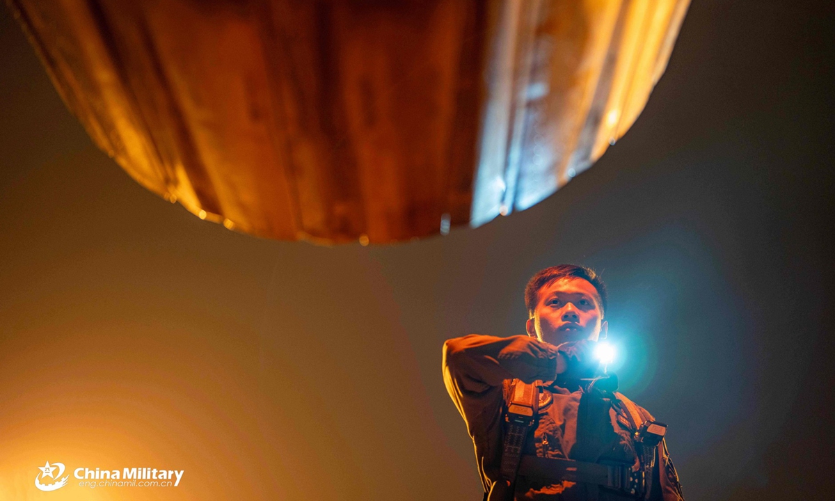 A pilot assigned to an aviation brigade with the air force under Chinese PLA Southern Theater Command inspects the exhaust nozzle before taking off for a nighttime flight training exercise. The exercise started at midnight and lasted until dawn. (eng.chinamil.com.cn/Photo by Wang Guoyun)