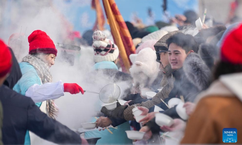 Tourists taste dumplings fresh from the pot during an ice collecting festival in Harbin, northeast China's Heilongjiang Province, Dec. 7, 2024. Marking the beginning of Harbin's ice collecting season, the fifth ice collecting festival kicked off here by the Songhua River on Saturday, attracting lots of people with ice collecting ceremony and performances. Photo: Xinhua