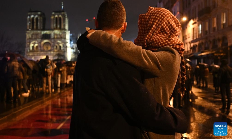 People gather outside the restored Notre-Dame de Paris cathedral in the rain in Paris, France, Dec. 7, 2024. Five years after being devastated by a fire, the restored Notre-Dame de Paris cathedral officially reopened on Saturday with a grand inauguration ceremony attended by world leaders, believers, and non-believers alike. Photo: Xinhua