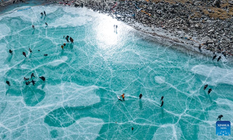 An aerial drone photo taken on Dec. 7, 2024 shows tourists enjoying themselves on an icy lake in front of the Mount Qungmknag in Nyemo County of Lhasa, southwest China's Xizang Autonomous Region. Photo: Xinhua