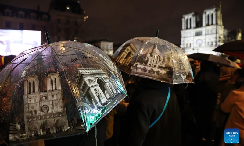 People gather outside the restored Notre-Dame de Paris cathedral in the rain in Paris, France, Dec. 7, 2024. Five years after being devastated by a fire, the restored Notre-Dame de Paris cathedral officially reopened on Saturday with a grand inauguration ceremony attended by world leaders, believers, and non-believers alike. Photo: Xinhua