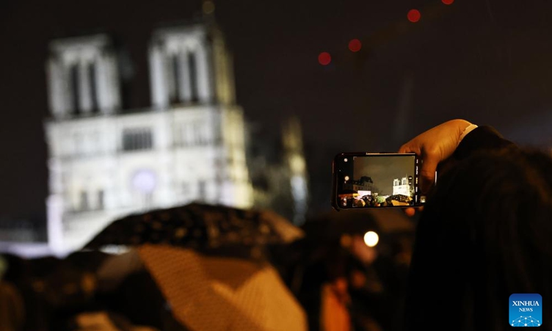 People gather outside the restored Notre-Dame de Paris cathedral in the rain in Paris, France, Dec. 7, 2024. Five years after being devastated by a fire, the restored Notre-Dame de Paris cathedral officially reopened on Saturday with a grand inauguration ceremony attended by world leaders, believers, and non-believers alike. Photo: Xinhua