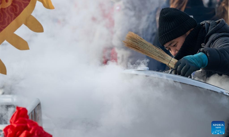 A staff member stews fish during an ice collecting festival in Harbin, northeast China's Heilongjiang Province, Dec. 7, 2024. Marking the beginning of Harbin's ice collecting season, the fifth ice collecting festival kicked off here by the Songhua River on Saturday, attracting lots of people with ice collecting ceremony and performances. Photo: Xinhua