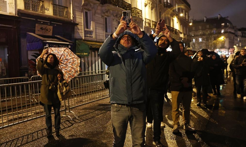 People take photos outside the restored Notre-Dame de Paris cathedral in the rain in Paris, France, Dec. 7, 2024. Five years after being devastated by a fire, the restored Notre-Dame de Paris cathedral officially reopened on Saturday with a grand inauguration ceremony attended by world leaders, believers, and non-believers alike. Photo: Xinhua