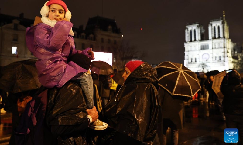 People gather outside the restored Notre-Dame de Paris cathedral in the rain in Paris, France, Dec. 7, 2024. Five years after being devastated by a fire, the restored Notre-Dame de Paris cathedral officially reopened on Saturday with a grand inauguration ceremony attended by world leaders, believers, and non-believers alike. Photo: Xinhua