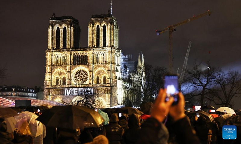 People gather outside the restored Notre-Dame de Paris cathedral in the rain in Paris, France, Dec. 7, 2024. Five years after being devastated by a fire, the restored Notre-Dame de Paris cathedral officially reopened on Saturday with a grand inauguration ceremony attended by world leaders, believers, and non-believers alike. Photo: Xinhua