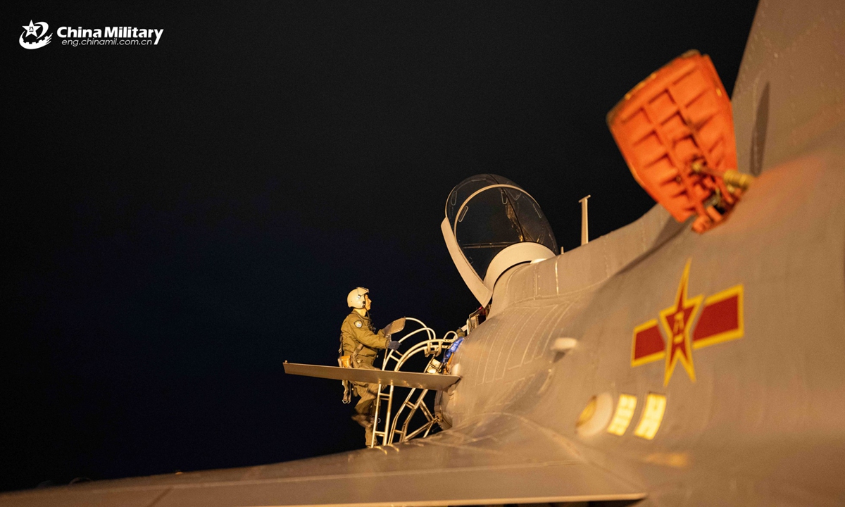 A pilot assigned to an aviation brigade with the air force under Chinese PLA Southern Theater Command climbs to the cockpit during a nighttime flight training exercise. The exercise started at midnight and lasted until dawn. (eng.chinamil.com.cn/Photo by Wang Guoyun)