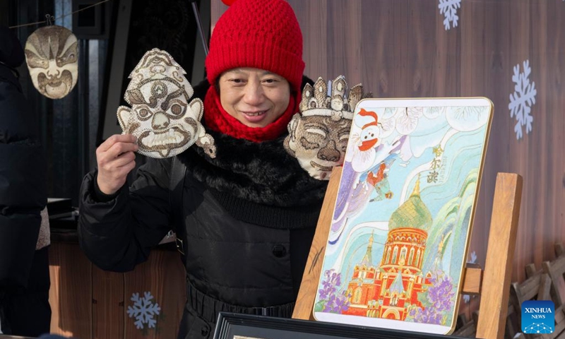 A tourist poses with fish skin ornaments during an ice collecting festival in Harbin, northeast China's Heilongjiang Province, Dec. 7, 2024. Marking the beginning of Harbin's ice collecting season, the fifth ice collecting festival kicked off here by the Songhua River on Saturday, attracting lots of people with ice collecting ceremony and performances. Photo: Xinhua