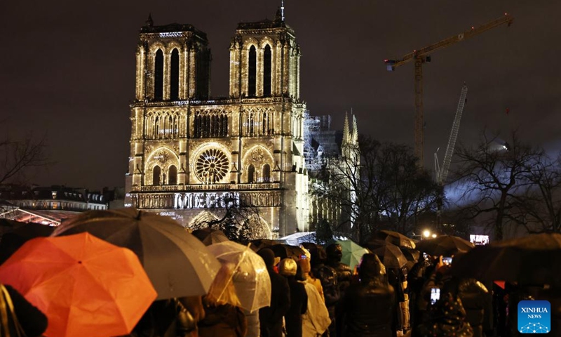 People gather outside the restored Notre-Dame de Paris cathedral in the rain in Paris, France, Dec. 7, 2024. Five years after being devastated by a fire, the restored Notre-Dame de Paris cathedral officially reopened on Saturday with a grand inauguration ceremony attended by world leaders, believers, and non-believers alike. Photo: Xinhua