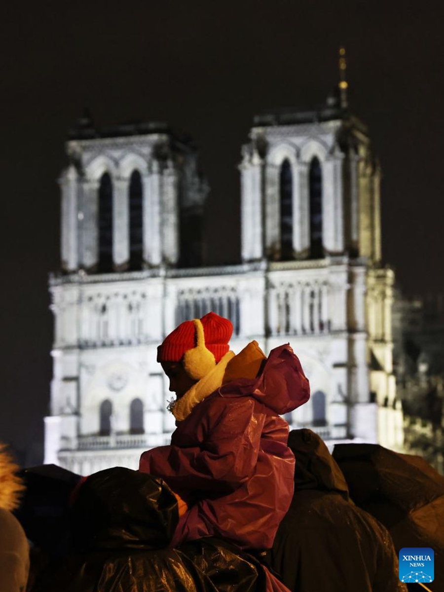 People gather outside the restored Notre-Dame de Paris cathedral in the rain in Paris, France, Dec. 7, 2024. Five years after being devastated by a fire, the restored Notre-Dame de Paris cathedral officially reopened on Saturday with a grand inauguration ceremony attended by world leaders, believers, and non-believers alike. Photo: Xinhua