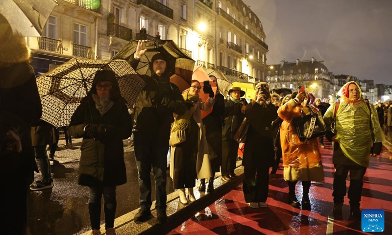 People gather outside the restored Notre-Dame de Paris cathedral in the rain in Paris, France, Dec. 7, 2024. Five years after being devastated by a fire, the restored Notre-Dame de Paris cathedral officially reopened on Saturday with a grand inauguration ceremony attended by world leaders, believers, and non-believers alike. Photo: Xinhua