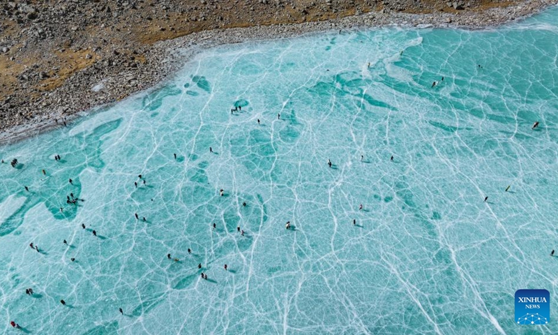 An aerial drone photo taken on Dec. 7, 2024 shows tourists enjoying themselves on an icy lake in front of the Mount Qungmknag in Nyemo County of Lhasa, southwest China's Xizang Autonomous Region. Photo: Xinhua