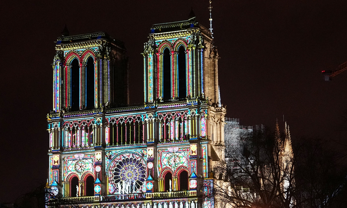 Crowds stand outside Notre-Dame de Paris cathedral as it is illuminated during a ceremony to mark the reopening of the landmark cathedral, in central Paris, on December 7, 2024. Photo: AFP