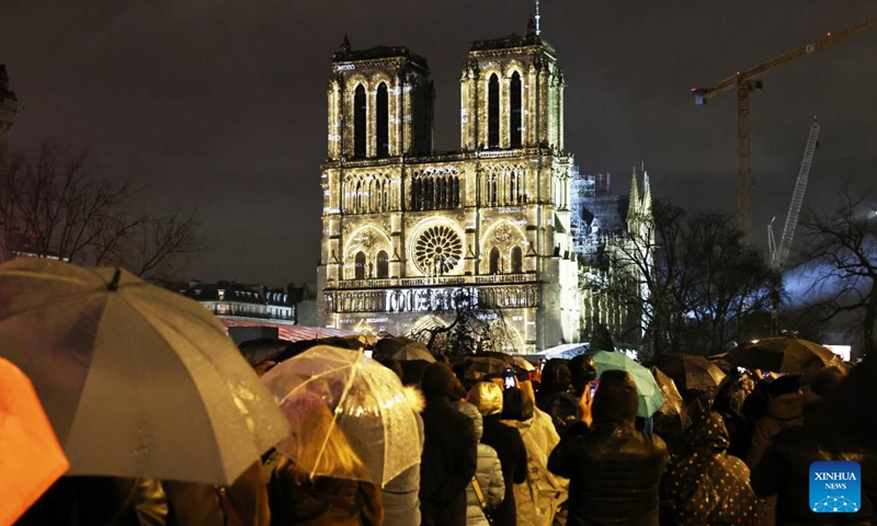 People gather outside the restored Notre-Dame de Paris cathedral in the rain in Paris, France, Dec. 7, 2024. Five years after being devastated by a fire, the restored Notre-Dame de Paris cathedral officially reopened on Saturday with a grand inauguration ceremony attended by world leaders, believers, and non-believers alike. Photo: Xinhua